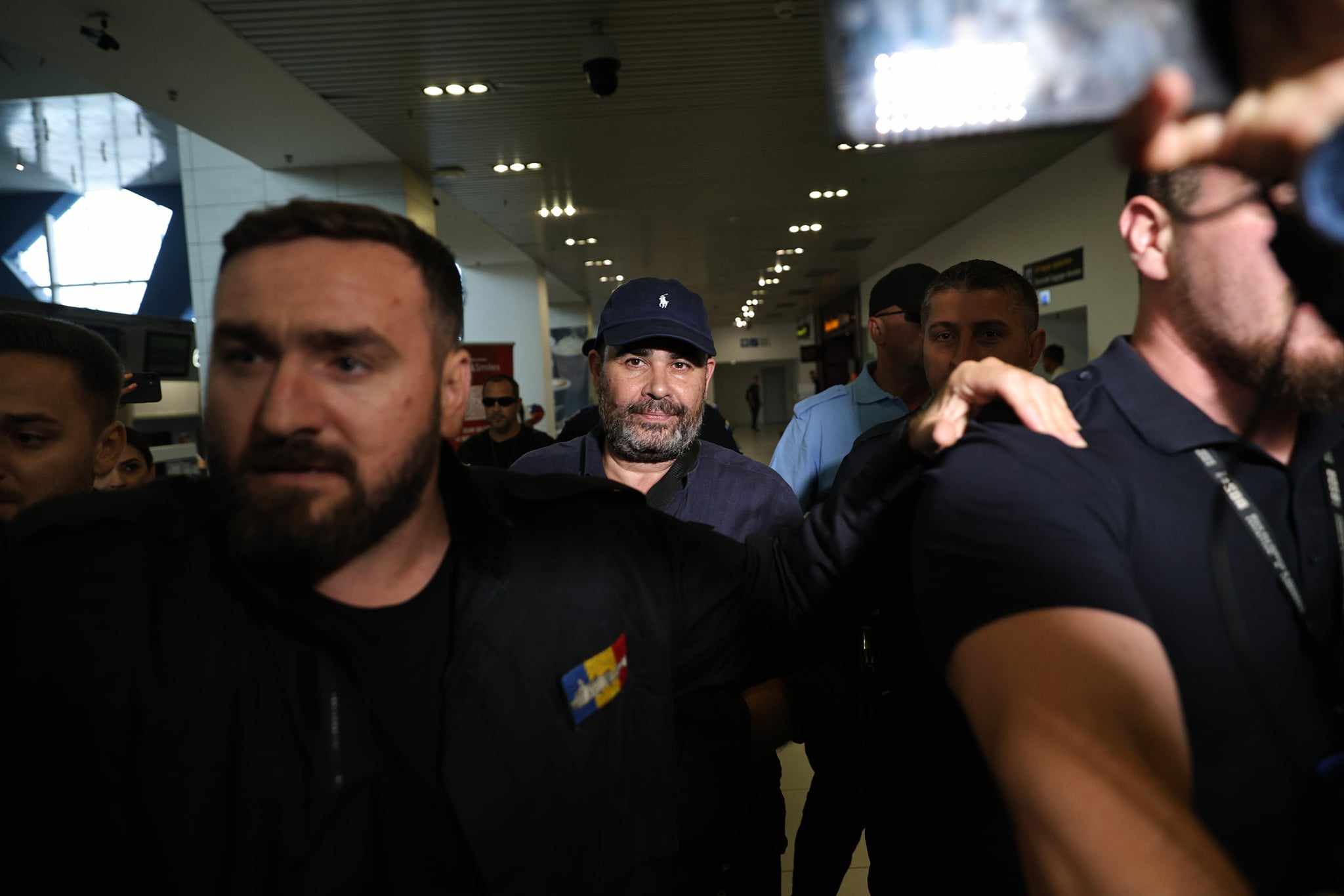Darius Vâlcov, extrădat din Italia: flancat de jandarmi pe Otopeni, până la mașina care l-a dus la penitenciar. Are de ispășit o pedeapsă de 6 ani de închisoare
