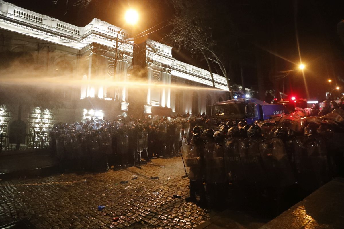 Imagine simbolică pentru 2023, la protestele din Georgia: manifestanți strânși în jurul steagului UE, fluturat de o femeie pe care autoritățile au pus tunul cu apă - VIDEO