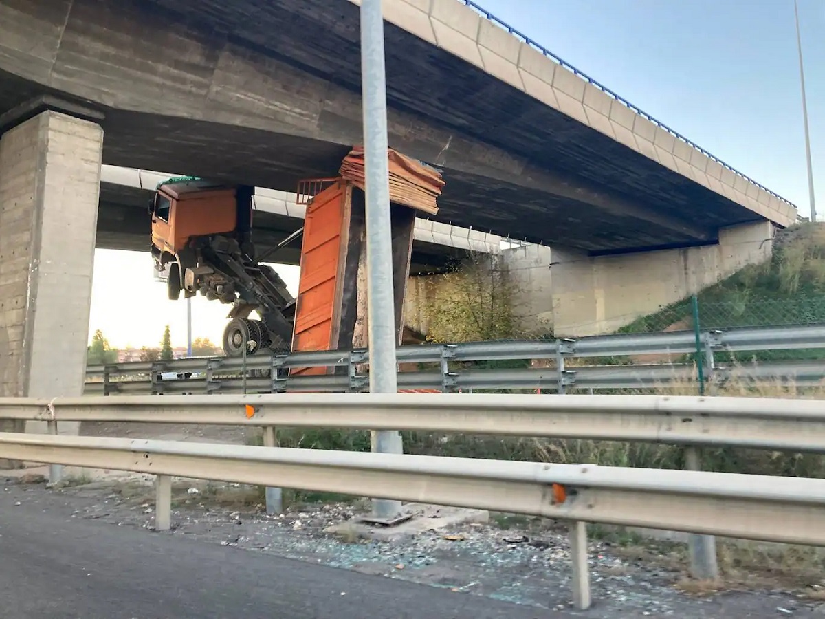 Șofer de basculantă, rămas suspendat în cabină, la 8 metri înălțime, sub un pod de lângă o autostradă din Spania