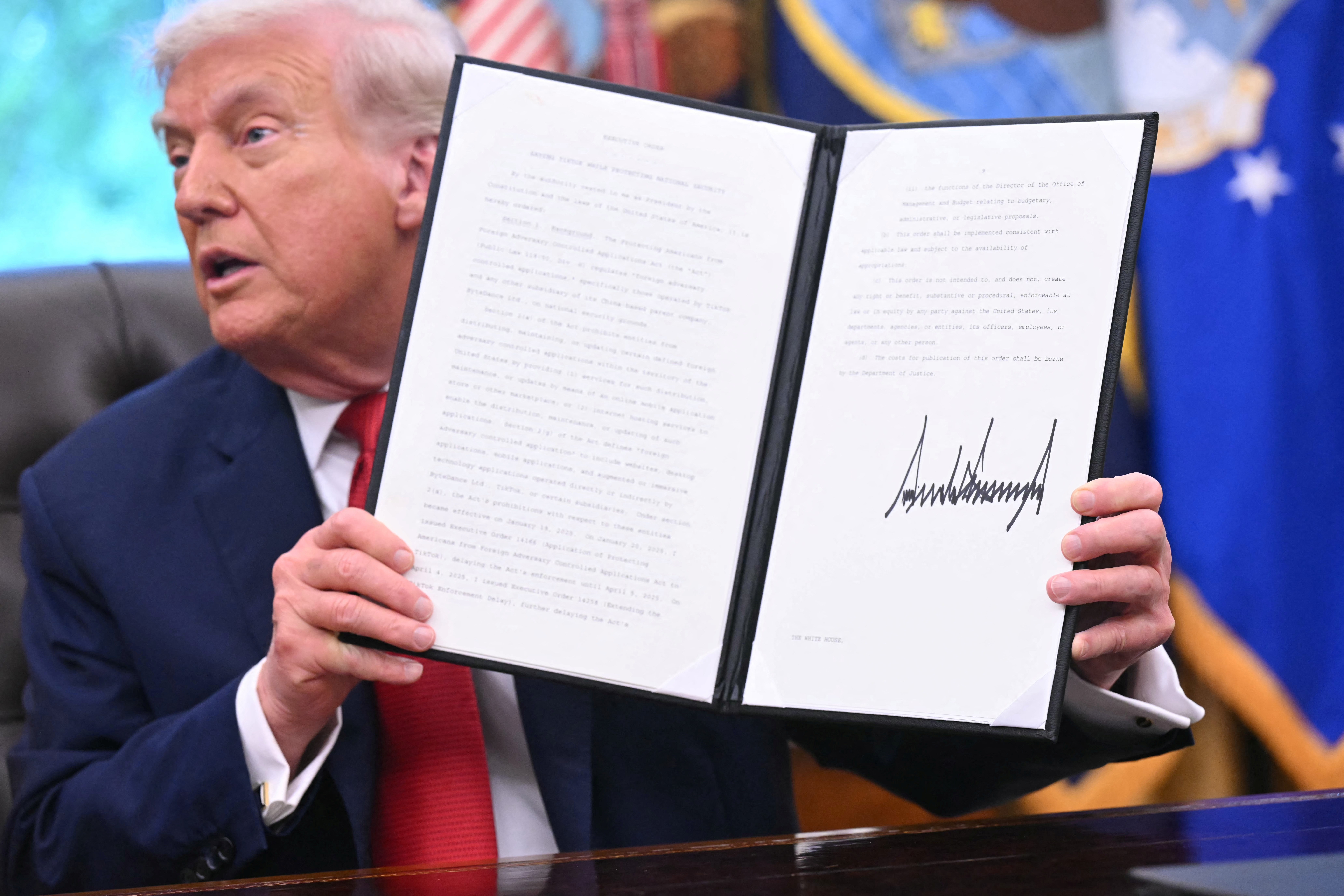 President Donald Trump shows off an executive order on Tiktok he signed in the Oval Office on September 25, 2025.