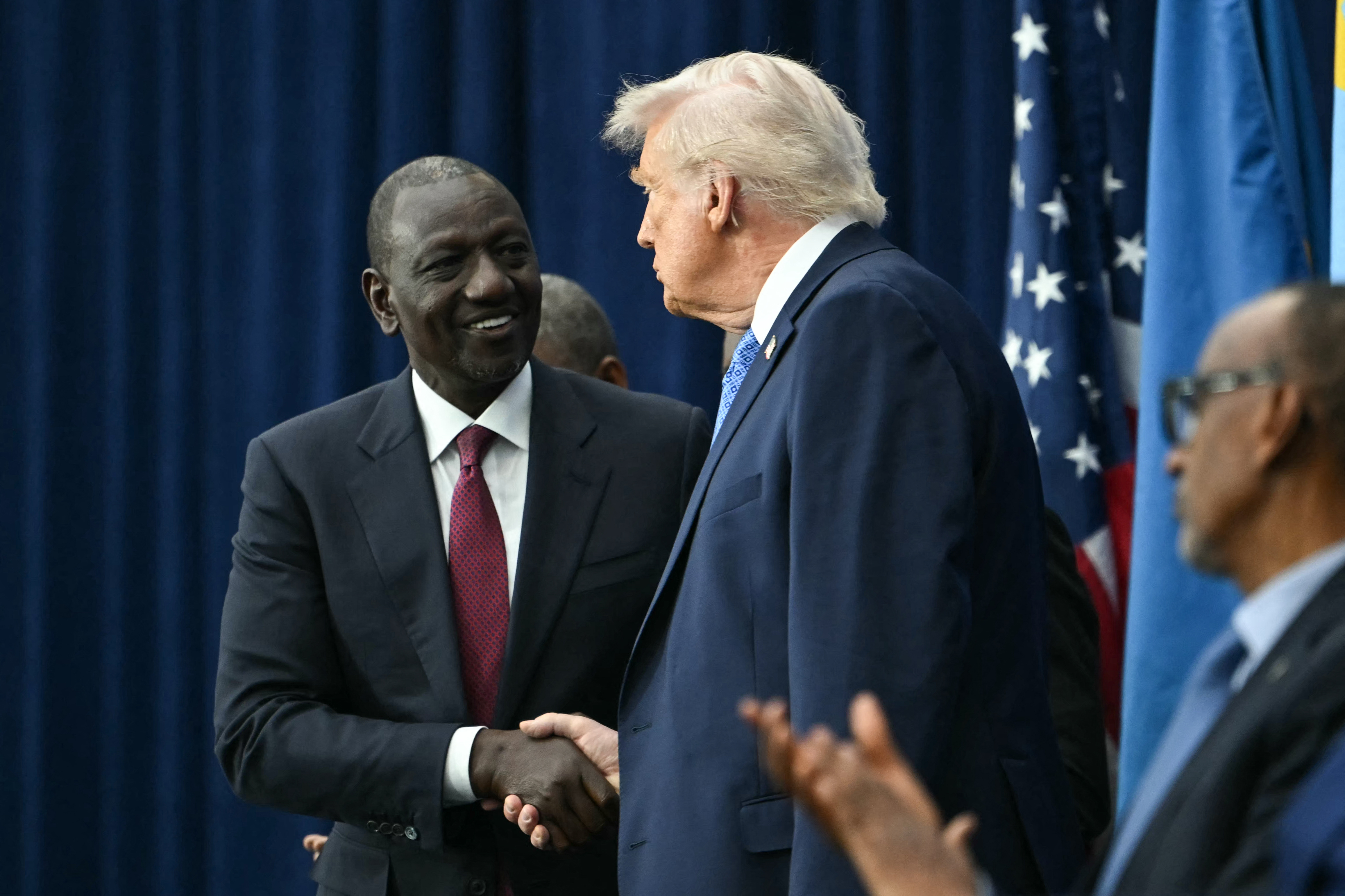 L-R: Kenya's President William Ruto shakes hands with US President Donald Trump during a signing ceremony hosted by Trump for a peace deal between Rwanda and the Democratic Republic of the Congo at the United States Institute of Peace in Washington, DC, on December 4, 2025. [Photo by ANDREW CABALLERO-REYNOLDS / AFP via Getty Images]