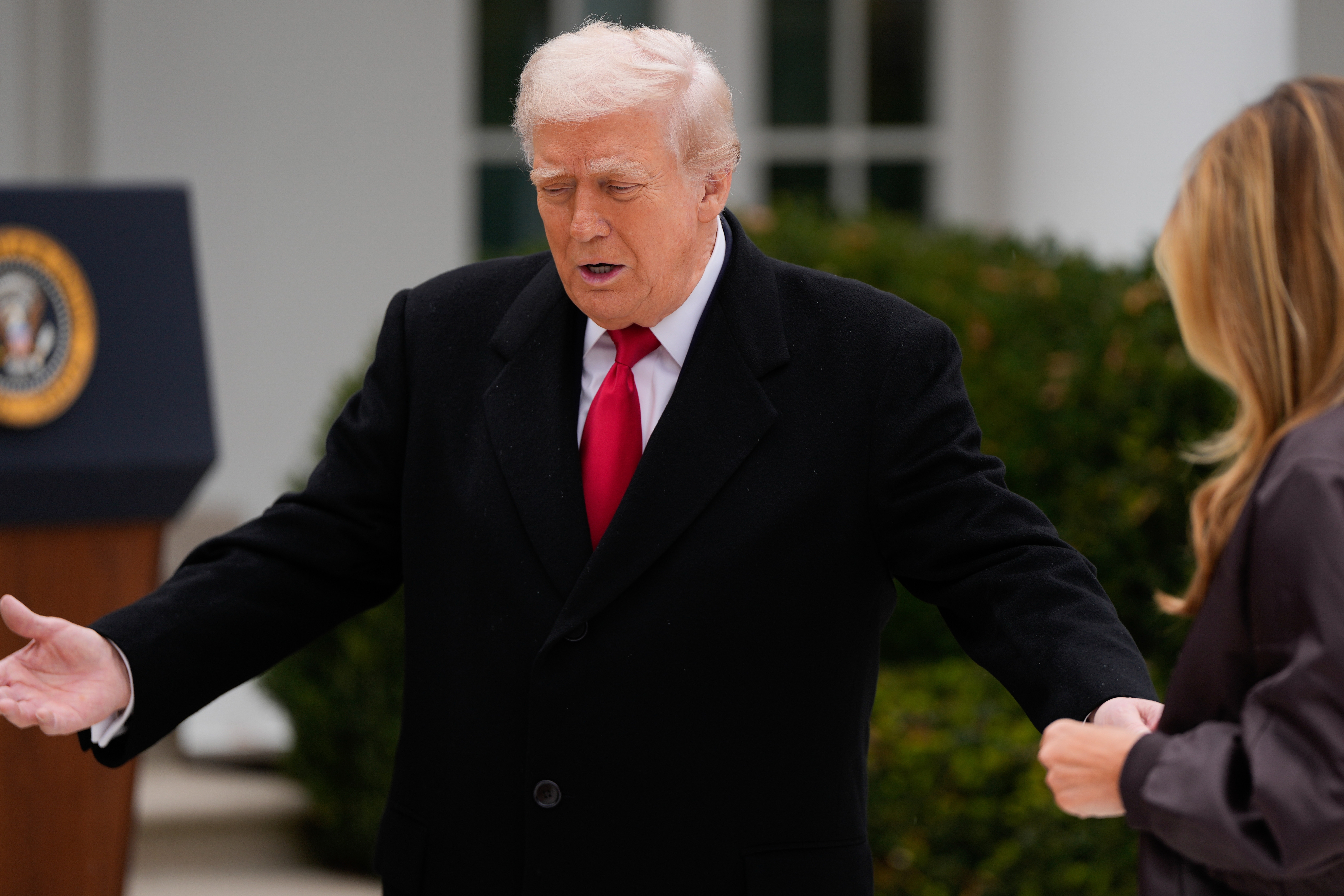 President Donald Trump reaches his hand out to first lady Melania Trump during the pardoning ceremony for the national Thanksgiving turkey Gobble, in the Rose Garden of the White House, Tuesday, Nov. 25, 2025, in Washington.