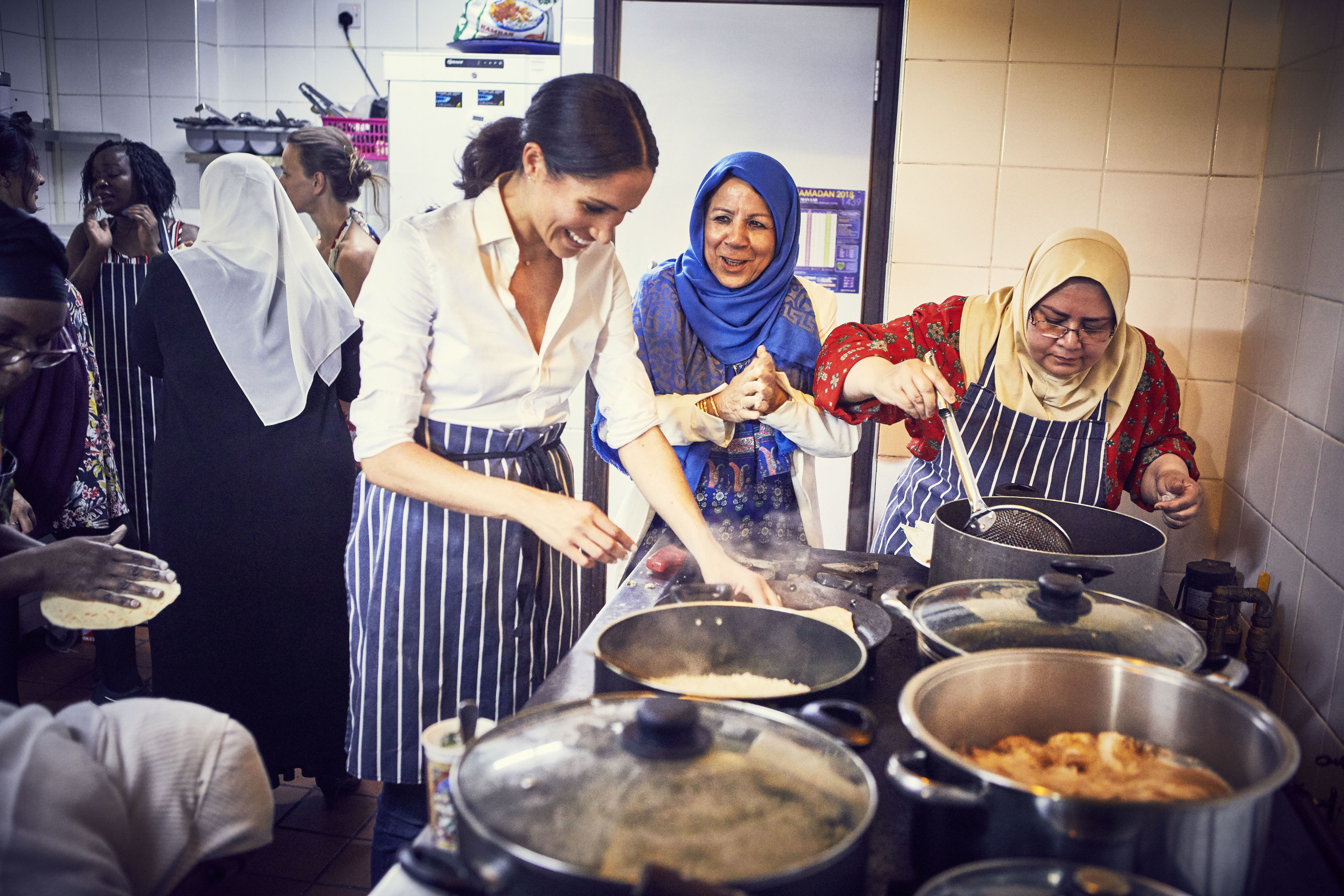 FOTO| Meghan Markle la cratiță. Ducesa de Sussex a ajutat la realizarea unei cărți de bucate pentru a-i ajuta pe supraviețuitorii incendiului de la Grenfell Tower