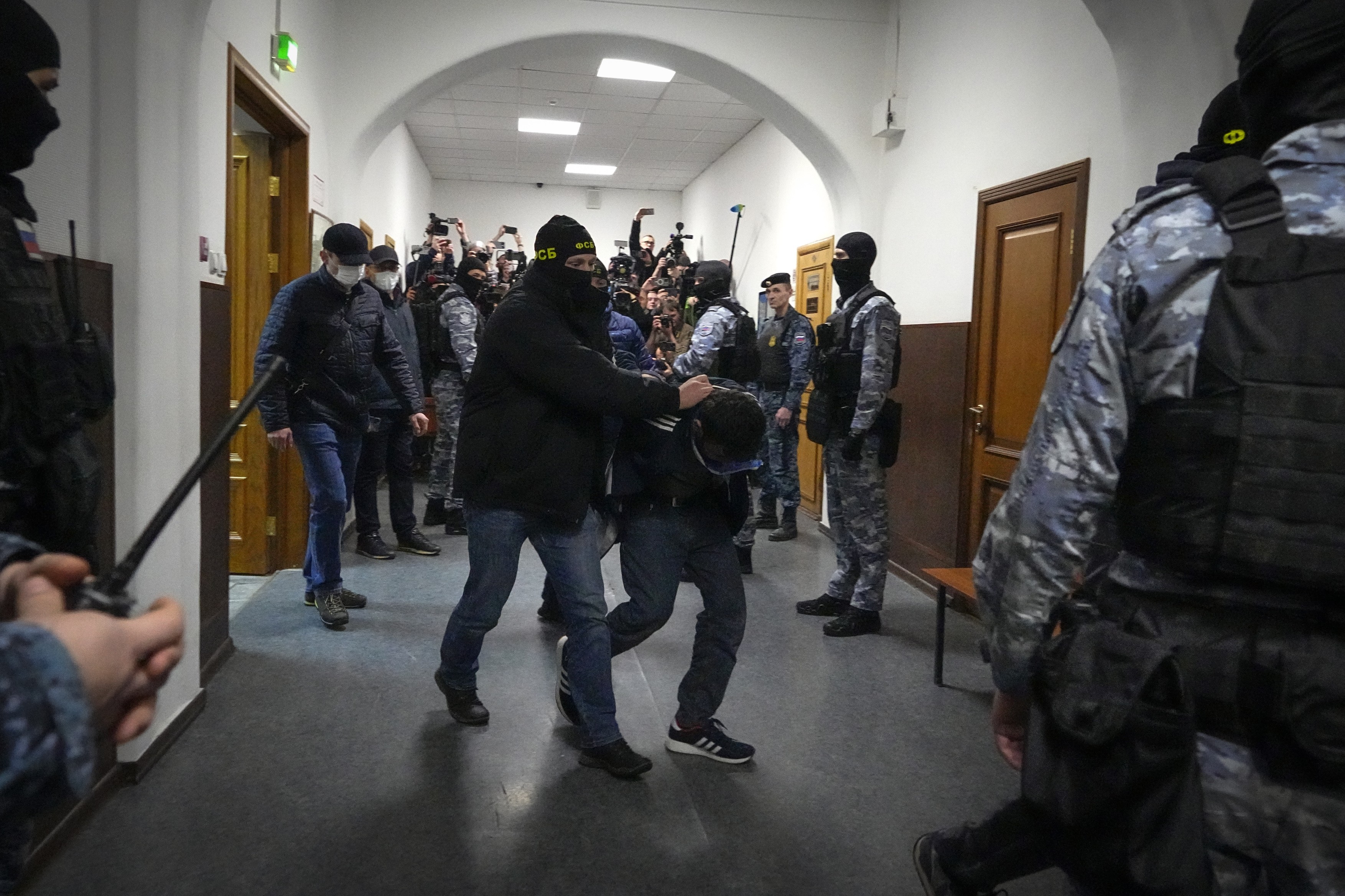 Doi suspecți în cazul atacului din Moscova, aduși la tribunal și inculpați. Amândoi au ochii învinețiți. Imagini cu ei pe banca acuzaților