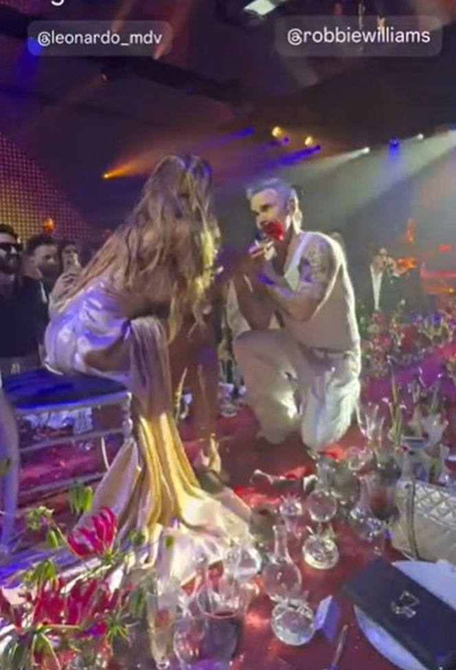 Robbie Williams, în genunchi în fața Mădălinei Ghenea. Moment spectaculos la petrecerea unui milionar italian