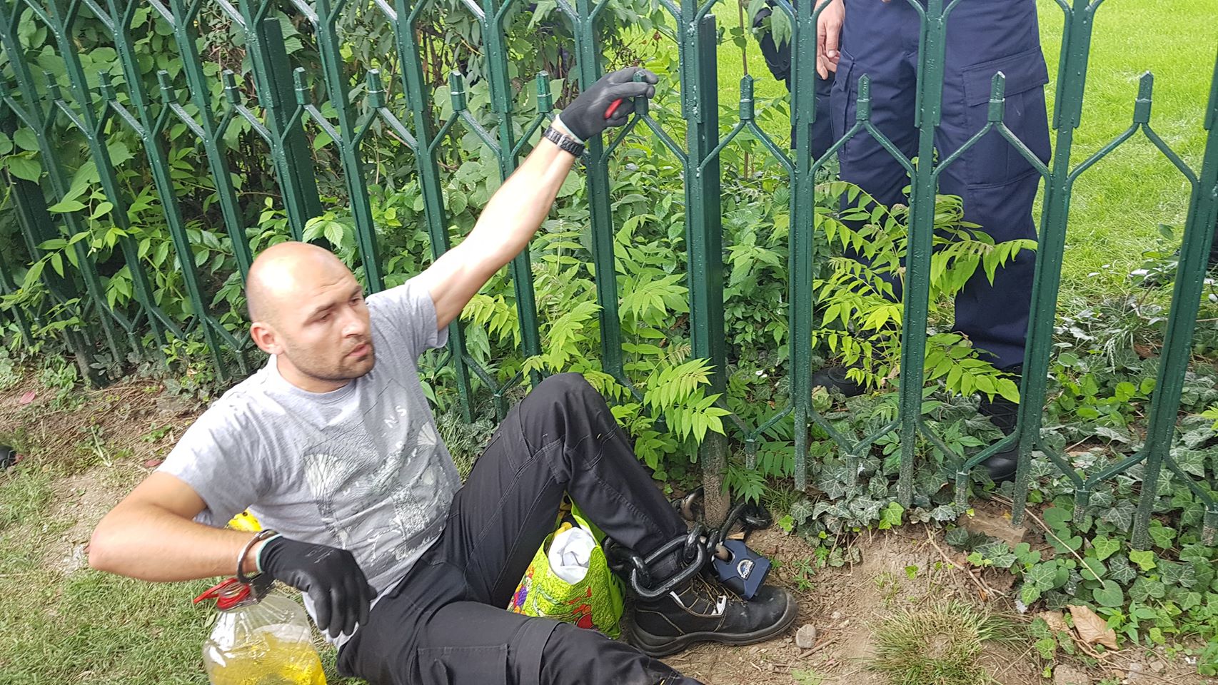 UPDATE. Bărbatul care s-a legat cu lanțul de gardul Guvernului și avea asupra lui o sticlă de benzină a fost descarcerat si ridicat de Jandarmerie (FOTO / VIDEO)