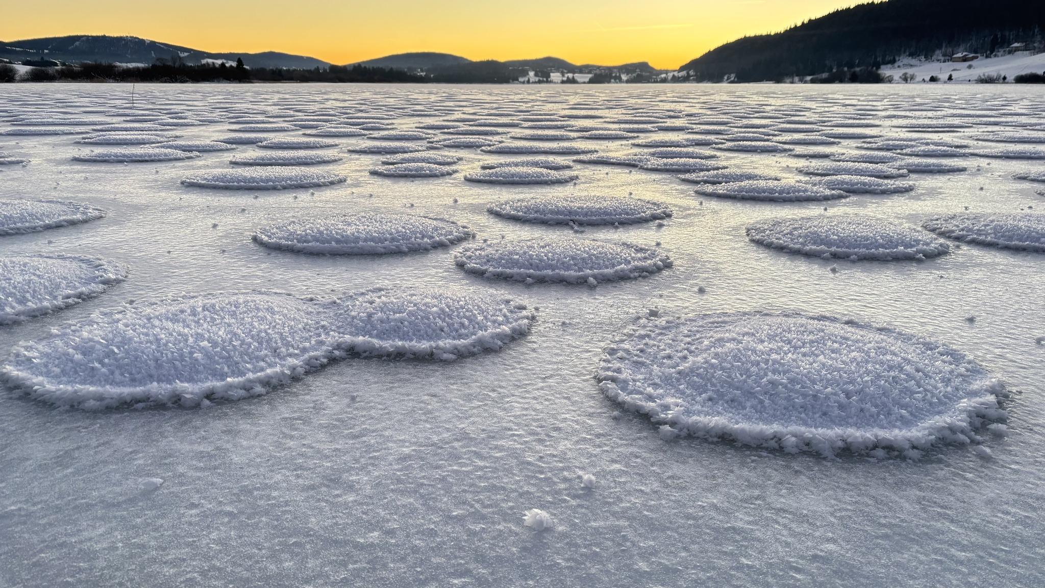 Fenomen rar și uluitor apărut în Franța, pe un lac înghețat. Ce sunt „clătitele de zăpadă” și cum se formează 