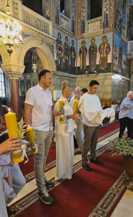 Anamaria Prodan și Ronald Gavril, în postura de nași de botez. Îmbrăcați în alb, au devenit părinții spirituali ai unui băiețel