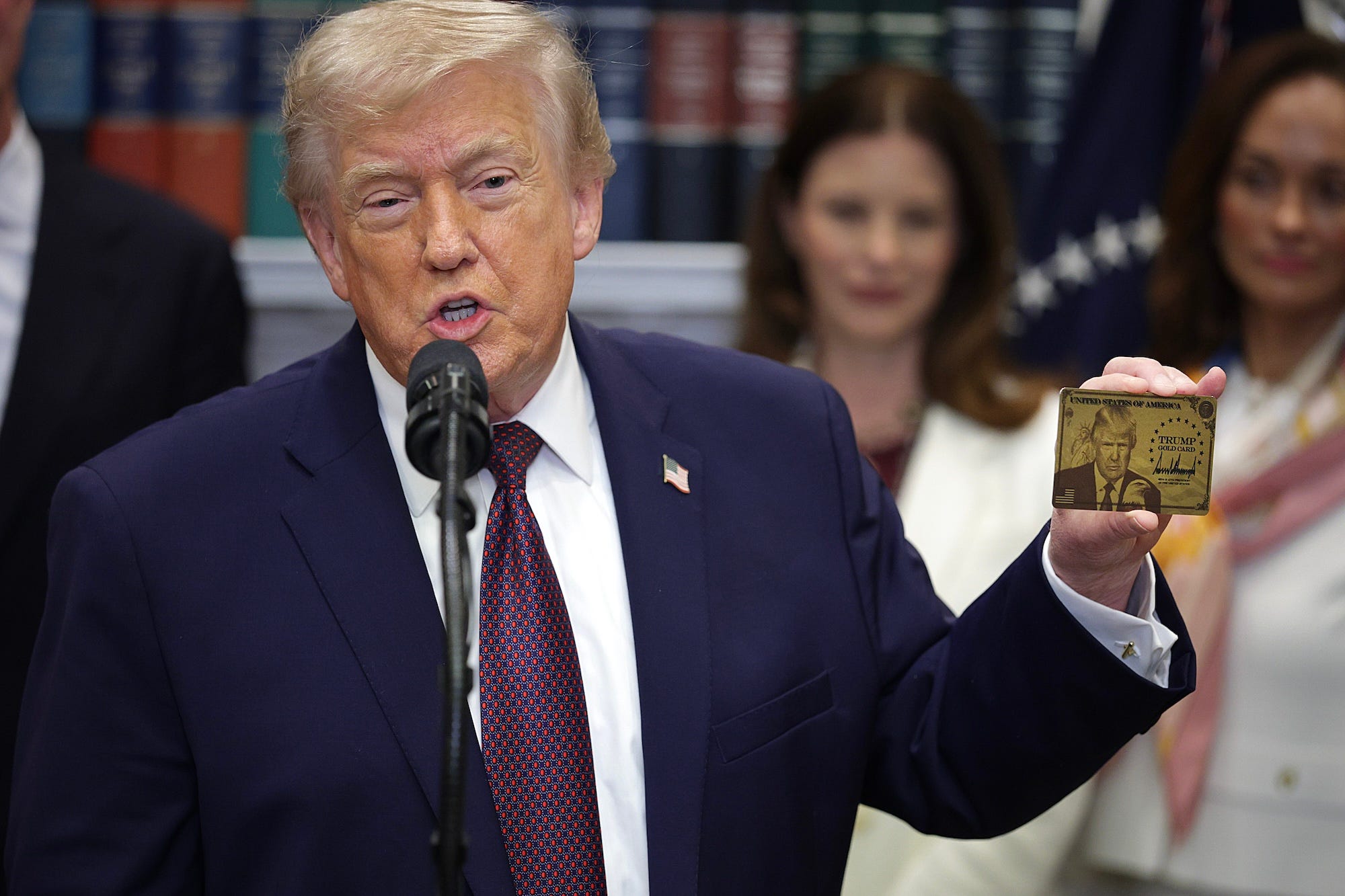 President Donald Trump holds up a Gold Card with his face on it at the White House in December.Alex Wong/Getty Images