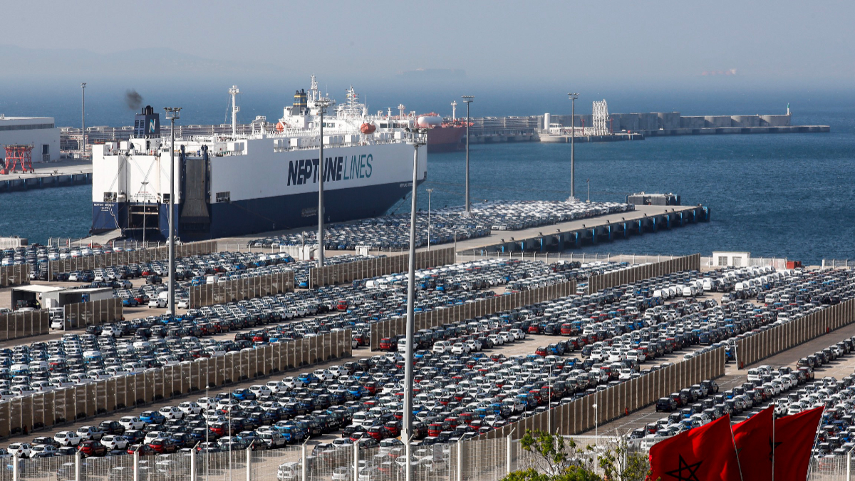 This picture, taken on June 28, 2019, shows a ship moored next to many cars at Terminal I of the Tanger Med port in the northern city of Tangiers on the Strait of Gibraltar. [Photo by AFP via Getty Images]