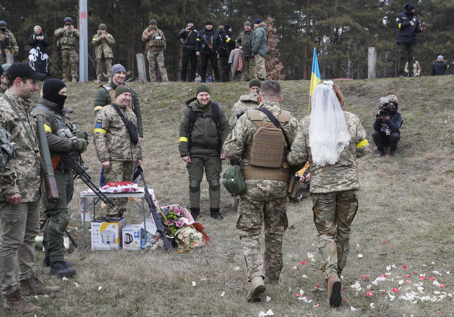 Nuntă pe front. În haine de camuflaj, cu alai înarmat cu flori și puști, doi militari ucraineni s-au căsătorit