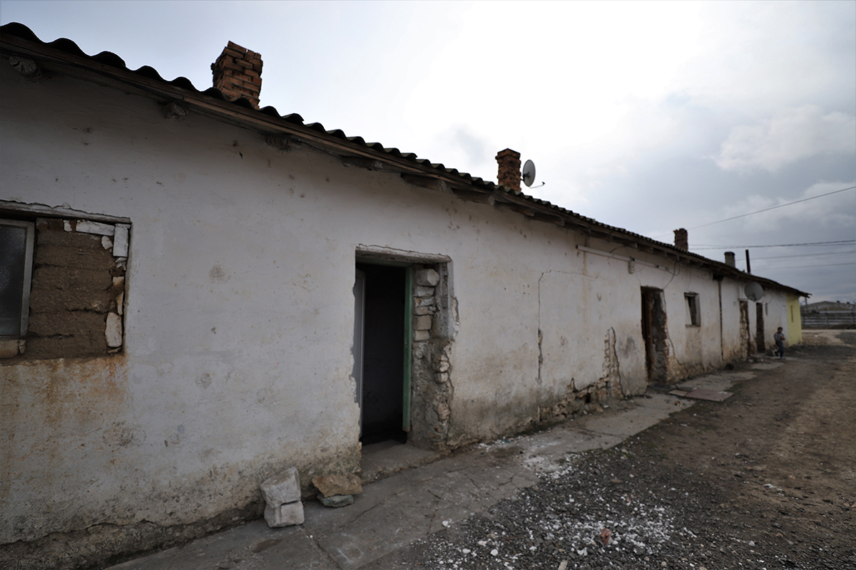 REPORTAJ. Peste 20 de familii dintr-un sat de lângă Mangalia plătesc chirie primăriei pentru că stau în clădirile fostului IAS. Unele au fost grajduri. „Am crescut cinci copii aici!”