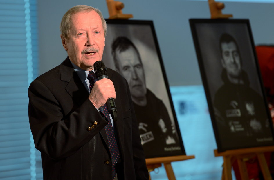 Janusz Onyszkiewicz podczas konferencji prasowej uczestników wyprawy na Broad Peak w 2013 r. W tle portrety Macieja Berbeki i Tomasza Kowalskiego, którzy zginęli podczas drogi powrotnej ze szczytu