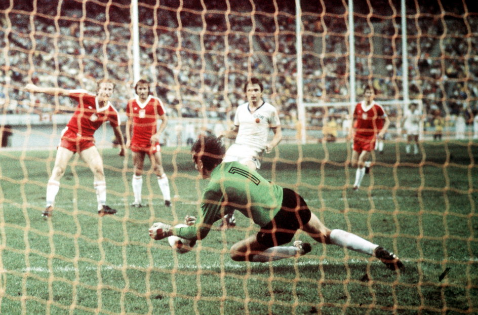 Juergen Croy zatrzymuje piłkę po strzale Andrzeja Szarmacha. Polski napastnik bramki w finale nie zdobył, ale z sześcioma golami został królem strzelców IO 1976