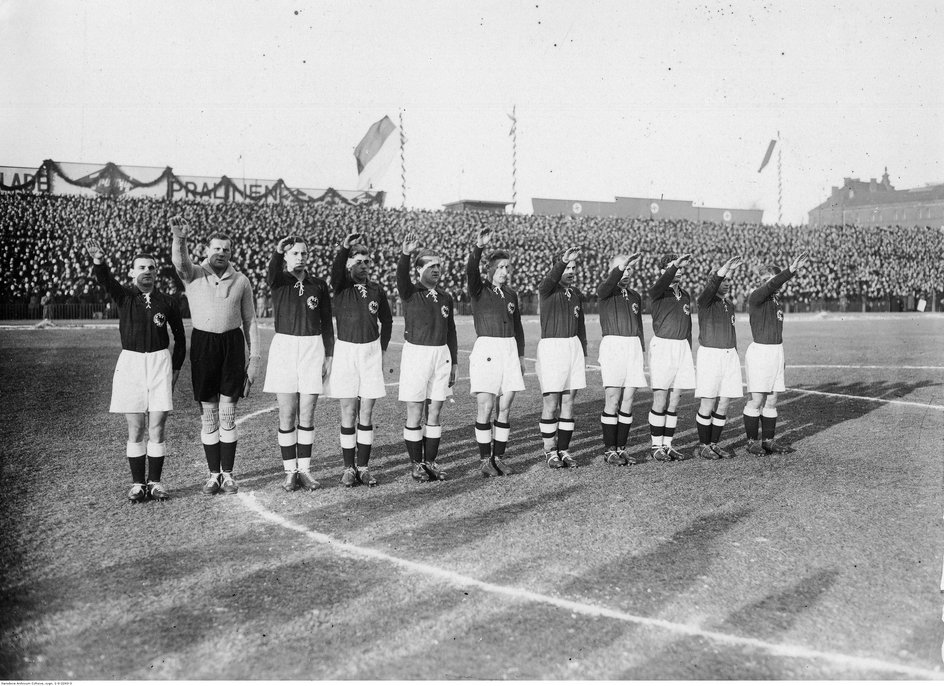 Piłkarze niemieccy salutują przed rozpoczęciem meczu, podczas wykonywania hymnu państwowego. Widoczni: Hans Jakob, Sigmund Haringer, Emil Krause, Paul Janes, Jakob Bender, Hans Appel, Ernst Lehner, Ludwig Lachner, Karl Hohmann, Josef Rasselnberg i Stanislaus Kobierski