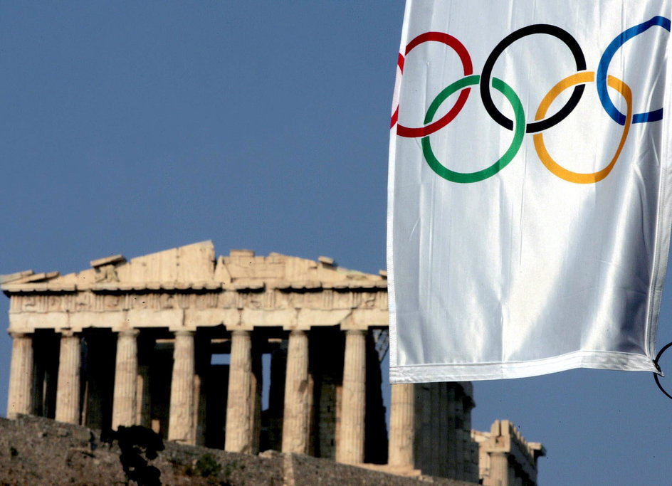 Współczesna flaga olimpijska u stóp Partenonu na Akropolu