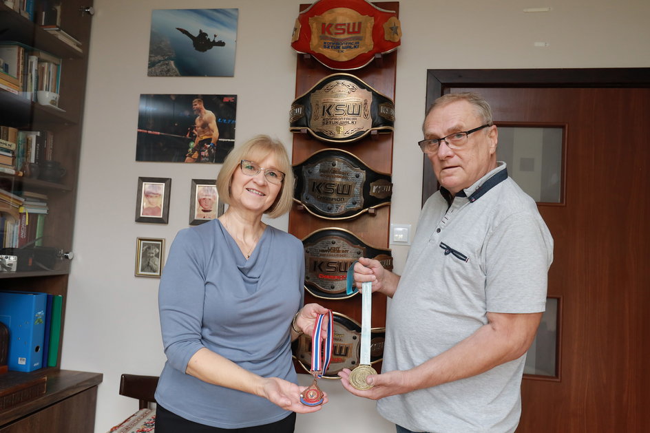 Krystyna i Stanisław Błachowiczowie, rodzice Jana, pokazują medale zdobyte przez syna w MŚ w muay thai w Bangkoku (2007, brąz) i Pusan (2008, złoto).