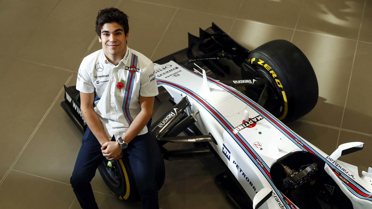 The newly announced Williams Martini Racing driver Lance Stroll poses for photographers beside this years Formula 1 car at their base in Wantage