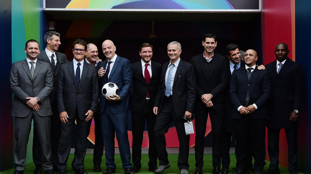 UEFA general secretary Gianni Infantino (4L) poses on the pitch at Wembley stadium with support from former players and managers (L-R) Pedrag Mijatovic, Francesco Toldo, Fabio Capello, Silvino Louro, Vladimir Smicer, former Chelsea coach Portugal's Jose M