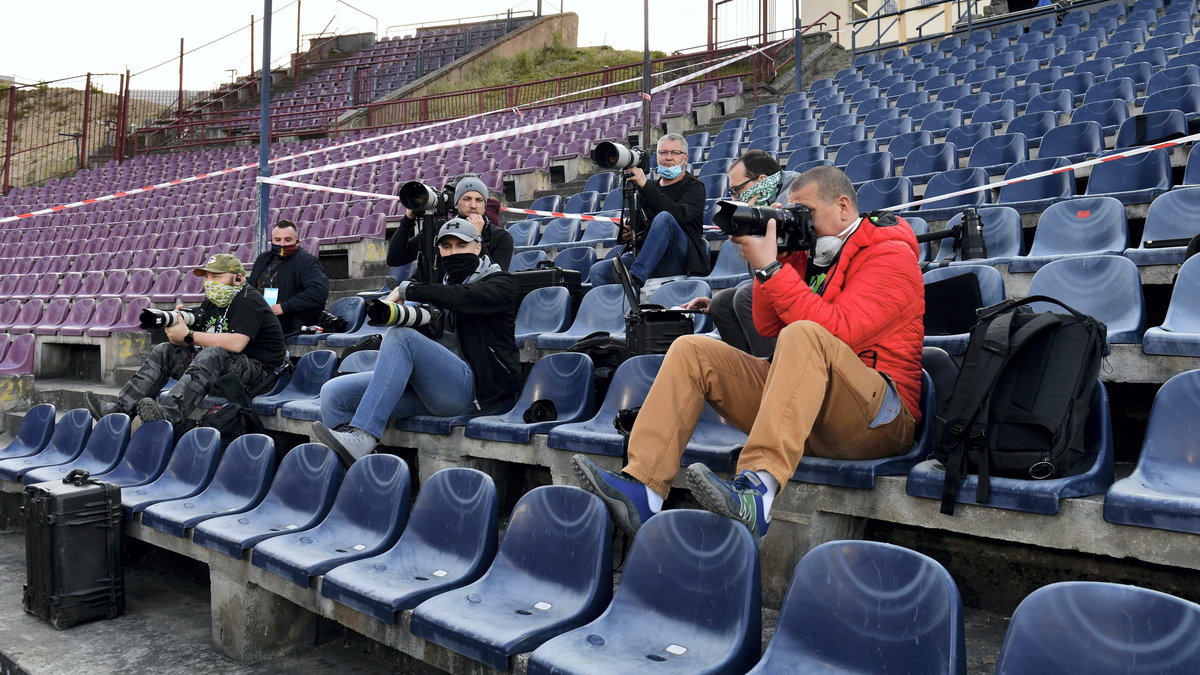 Dziennikarze pracujący na pustym stadionie w Szczecinie 