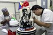 Cake decorator puts finishing touches to a two-layer cake featuring boxer Manny Pacquiao of the Philippines at a bakery in Manila