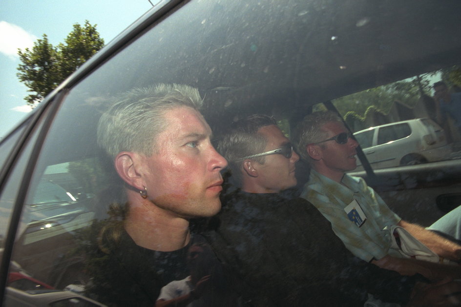 Kolarze Laurent Brochard, Richard Virenque i Pas cal Herve jadą na komendę policji w związku z aferą dopingową z 1998 r.