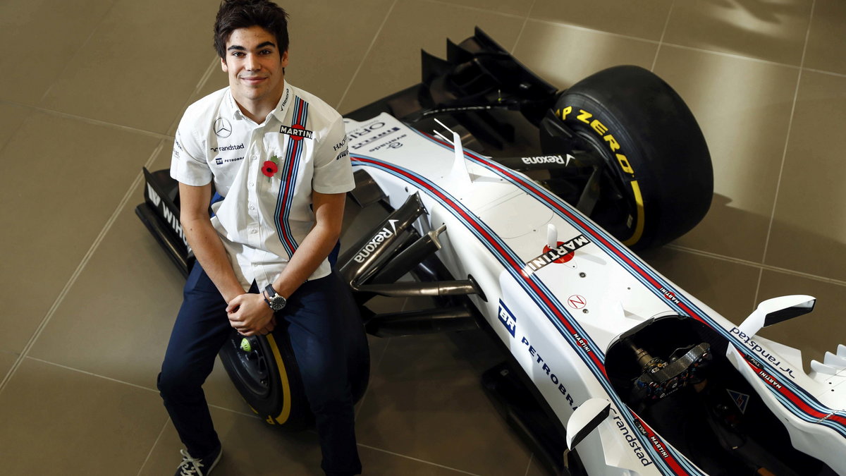 The newly announced Williams Martini Racing driver Lance Stroll poses for photographers beside this years Formula 1 car at their base in Wantage