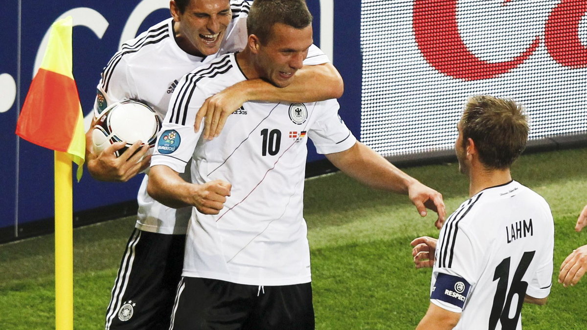 Germany's Podolski celebrates with team mates Gomez and Lahm after scoringsa goal against Denmark during their Euro 2012 Group B soccer match at the new stadium in Lviv