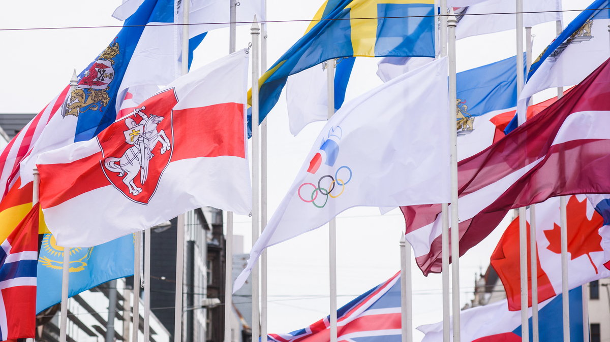 Historyczna biało-czerwono-biała flaga Białorusi, a obok niej flaga Rosyjskiego Komitetu Olimpijskiego