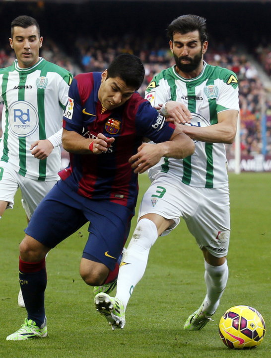 Barcelona's player Luis Suarez fights for the ball against Cordoba's Jose Angel Crespo during their Spanish First division soccer match at Camp Nou stadium in Barcelona