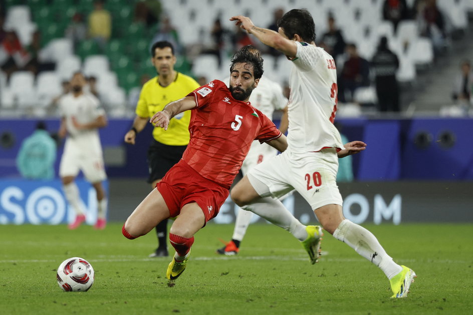 Palestyński obrońca Mohammed Saleh  (w czerwonym stroju) w meczu z Iranem w Pucharze Azji
