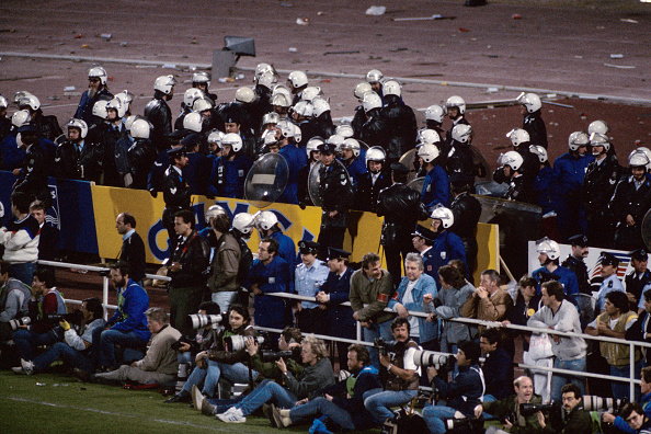 Belgijska policja osłaniająca fotoreporterów podczas zamieszek na Heysel