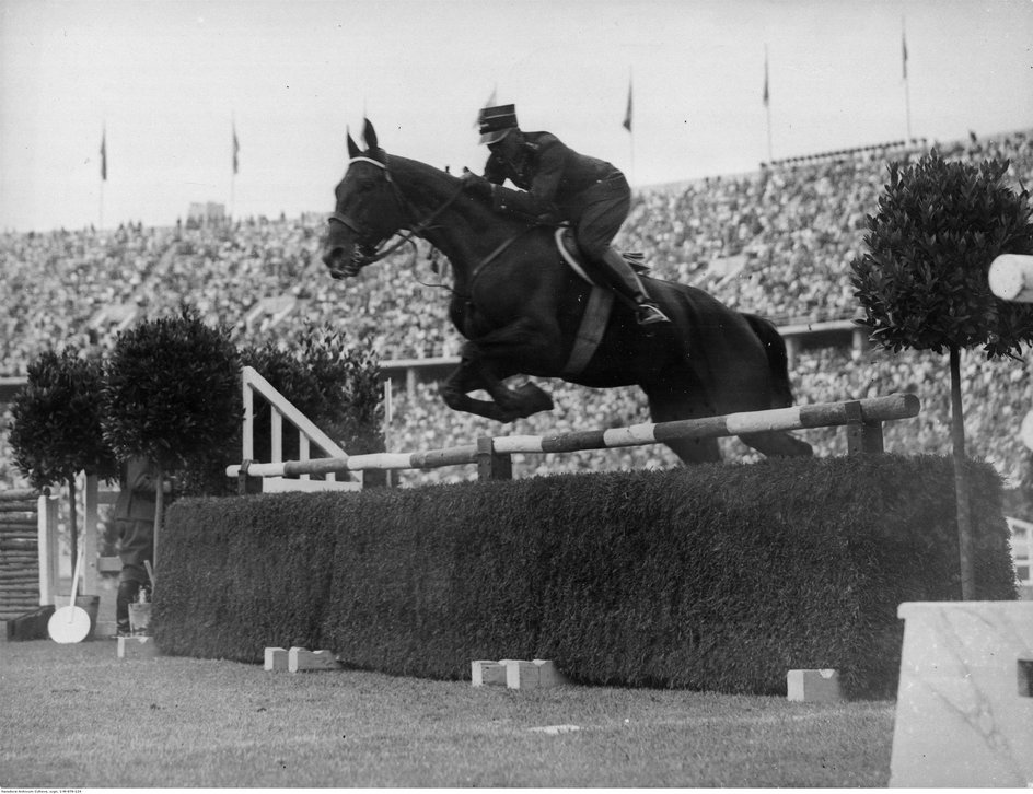 Henryk Leliwa-Roycewicz pokonuje przeszkodę na Arlekinie podczas zawodów hippicznych na igrzyskach olimpijskich w Berlinie 1936. Wraz ze Zdzisławem Kaweckim i Sewerynem Kuleszą zdobył srebro w drużynowym WKKW. (fot. NAC)