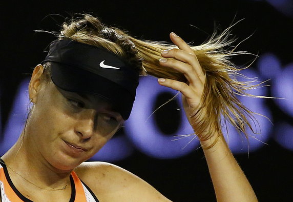 Russia's Sharapova adjusts her hair during her fourth round match against Switzerland's Bencic at the Australian Open tennis tournament at Melbourne Park