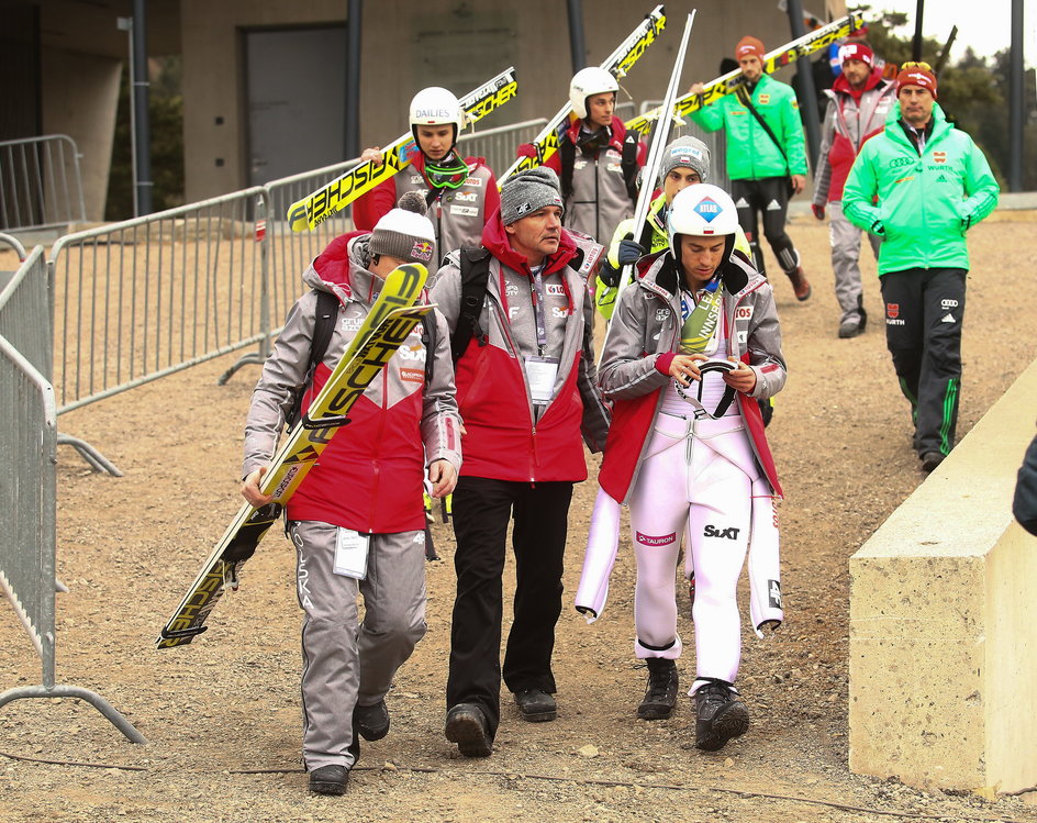 Kamil Stoch z doktorem Aleksandrem Winiarskim i Adamem Małyszem po upadku w Innsbrucku