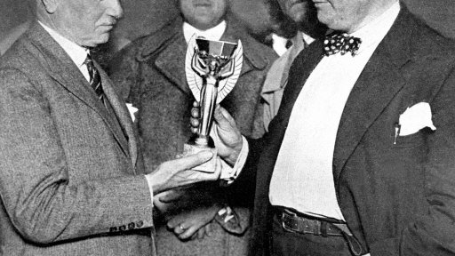 Jules Rimet (z lewej) wręcza trofeum za zwycięstwo w pierwszych MŚ prezydentowi Urugwajskiego Związku Piłki Nożnej, Raulowi Jude