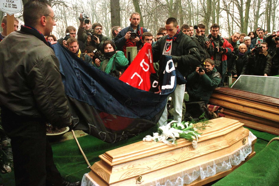 Pogrzeb Przemka Czai. Kibice Czarnych Słupsk zdejmują klubową flagą przed złożeniem trumny w grobie