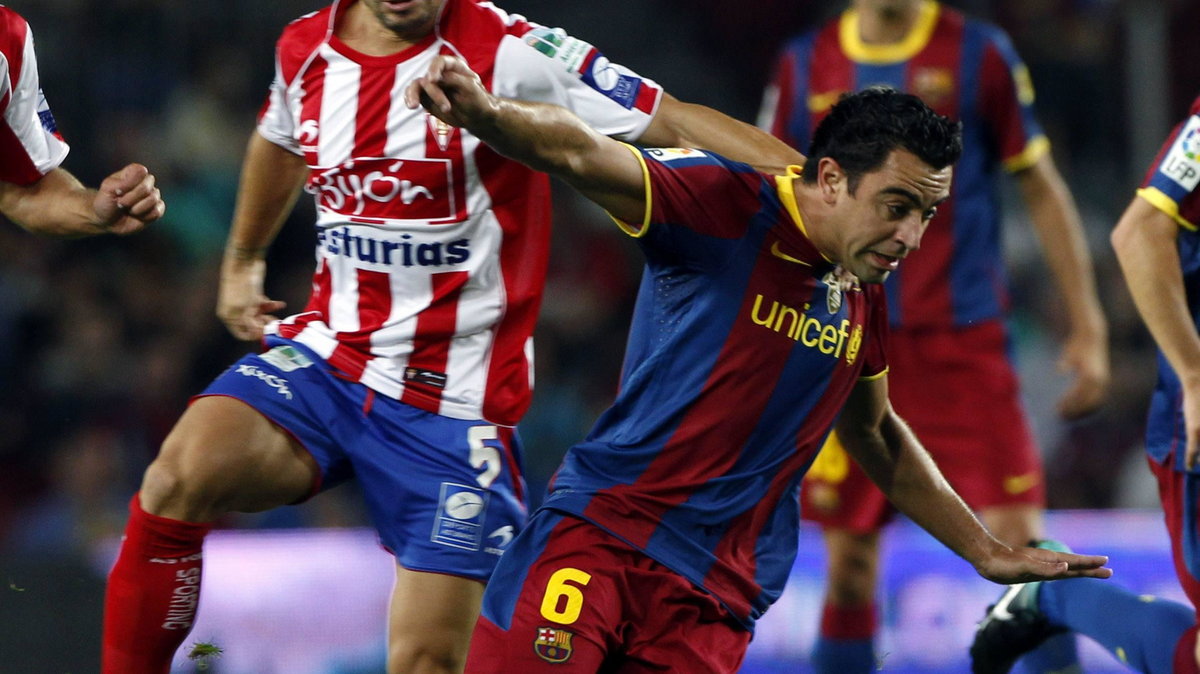 Xavi Hernandez (P) w starciu z Alberto Riverą z Atletico Madryt