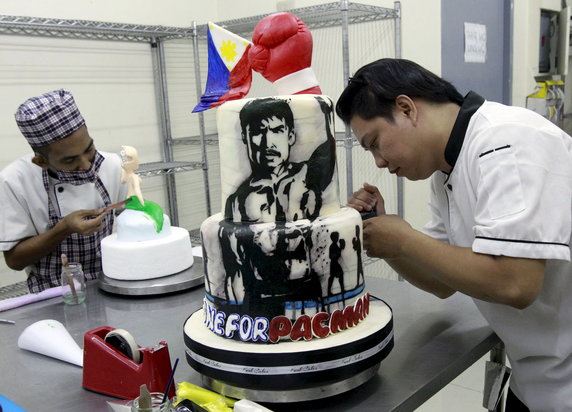 Cake decorator puts finishing touches to a two-layer cake featuring boxer Manny Pacquiao of the Philippines at a bakery in Manila