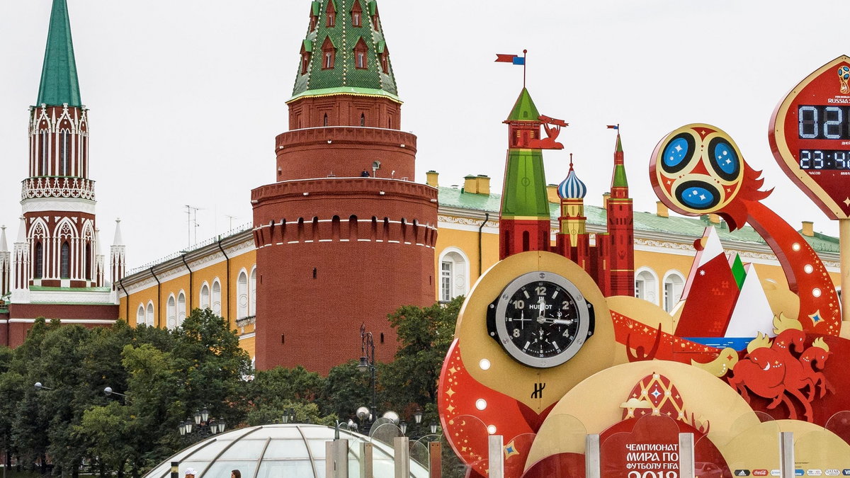 A couple walks in front of the digital FIFA World Cup 2018 countdown clock placed in front of the Red Square and the Kremlin in Moscow on September 13, 2017. FIFA announced that ticket sales for the 2018 World Cup will begin on September 14, 2017, nine mo