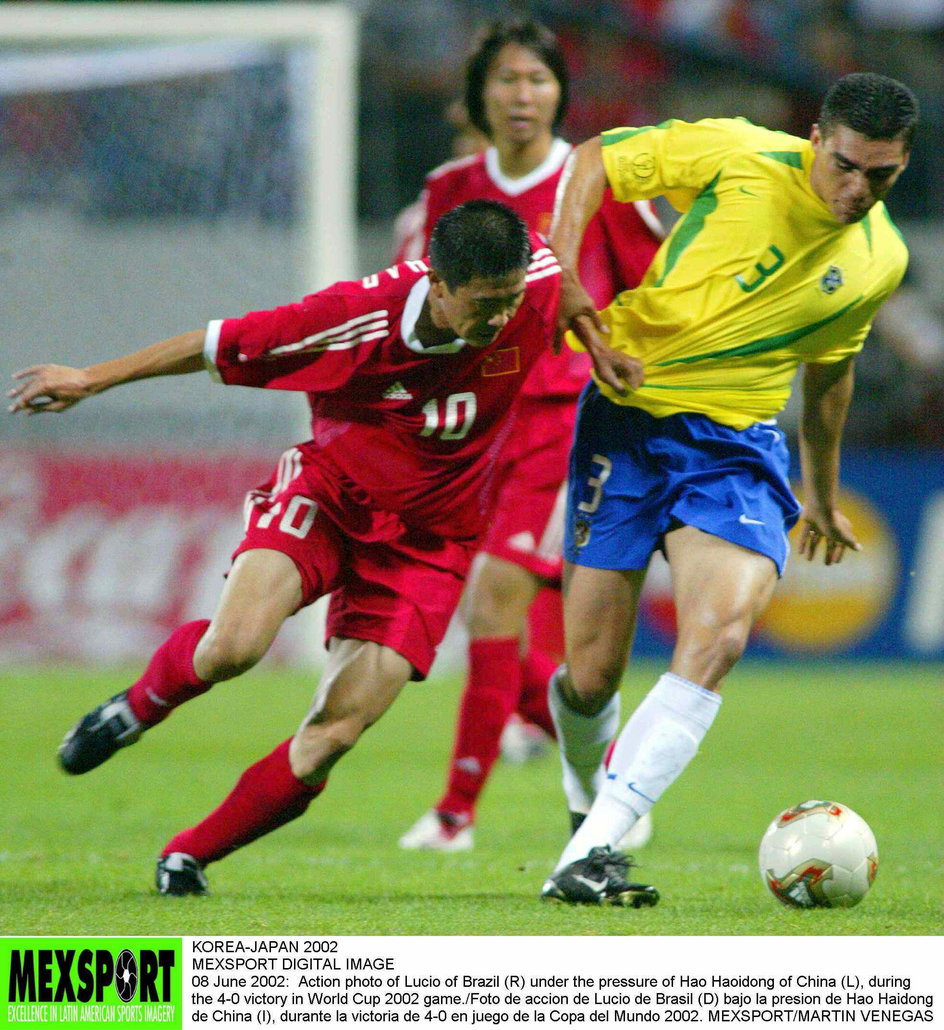 Hao Haidong rywalizujący o piłkę z Lucio podczas meczu Chiny - Brazylia na mundialu w 2002 roku.