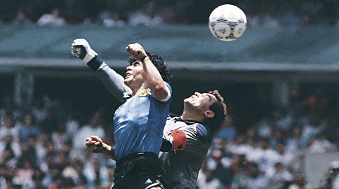 Diego Maradona strzelający bramkę "ręką Boga" Peterowi Shiltonowi podczas mundialu w 1986 r.