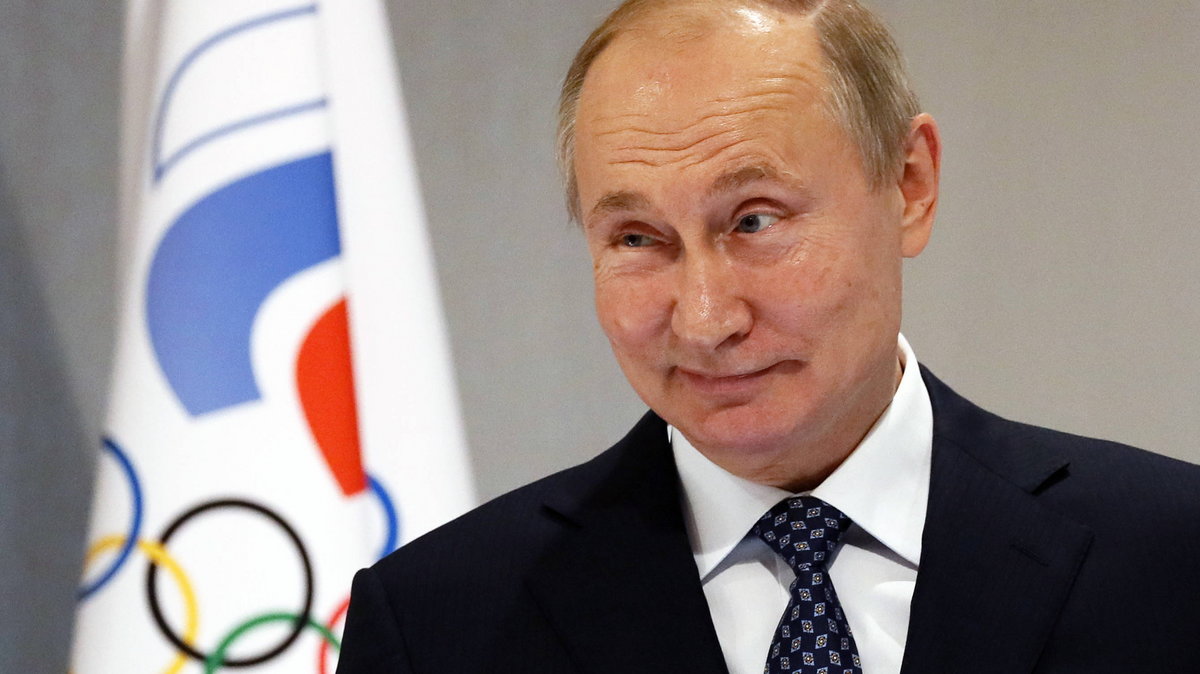 Władimir Putin na tle flagi z logo Rosyjskiego Komitetu Olimpijskiego
