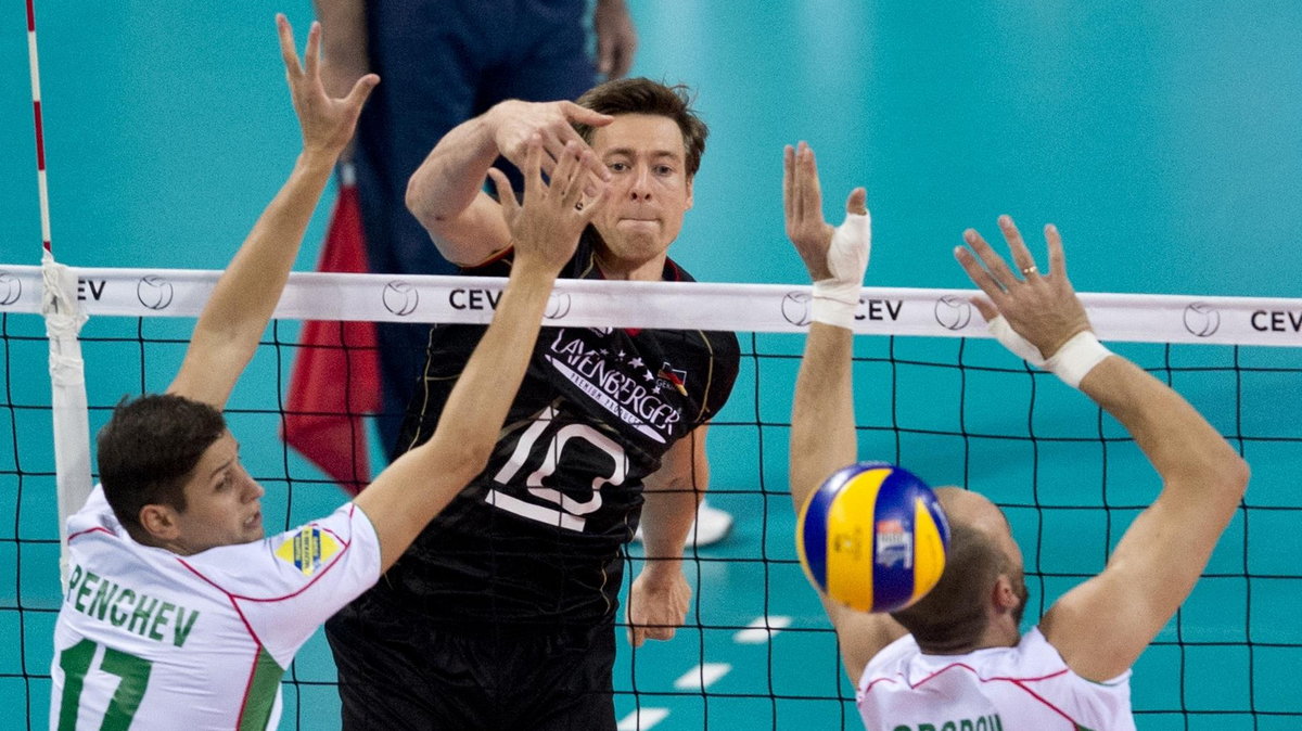 Germany's Jochen Schops (R) hits a return to Bulgaria's Nikolay Penchev and Teodor Todorov during the 2015 European Volleyball Championships quarter-final match between Bulgaria and Germany in Sofia on October 14, 2015. AFP PHOTO / NIKOLAY DOYCHINOV