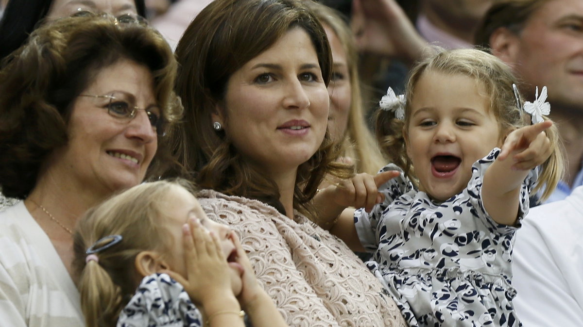The wife of Roger Federer of Switzerland, Mirka Federer, with their twins, celebrates after Federer defeated Andy Murray of Britain in their men's singles final tennis match at the Wimbledon Tennis Championships in London