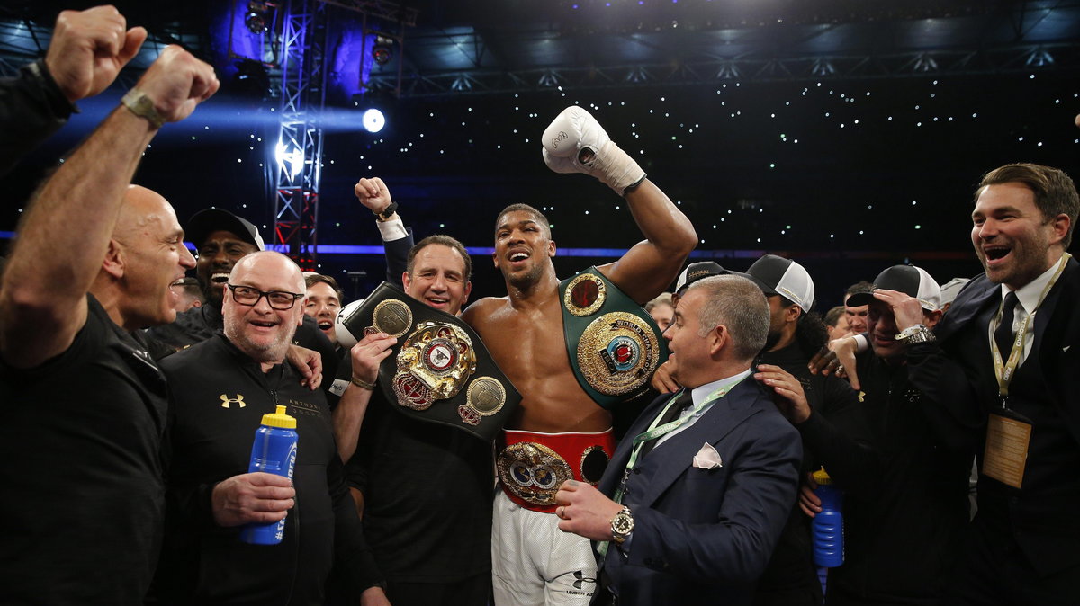 Anthony Joshua celebrates with trainer Robert McCracken and promoter Eddie Hearn after winning the fight