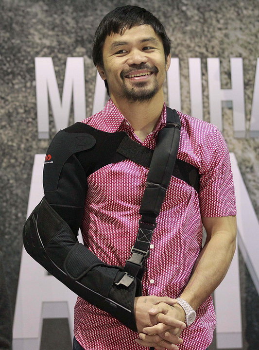 Boxer Manny Pacquiao smiles upon his arrival at the international airport in Manila