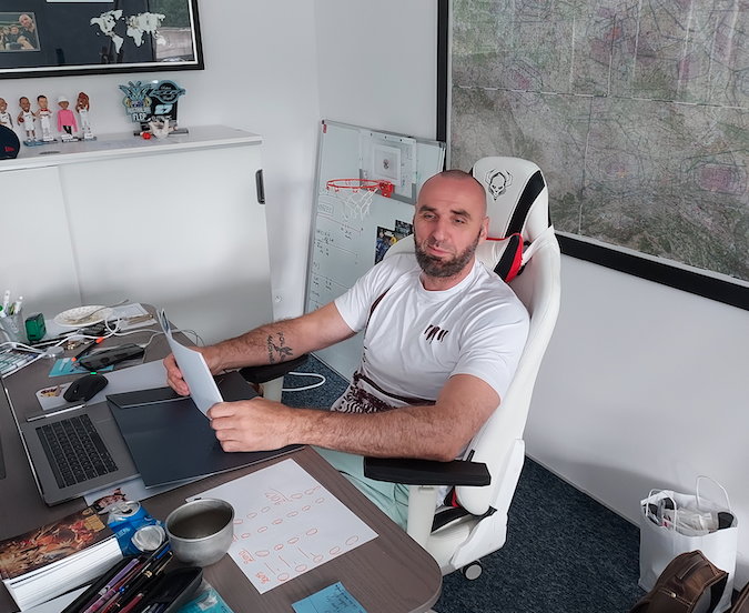 Marcin Gortat przy biurku w siedzibie swojej fundacji MG 13