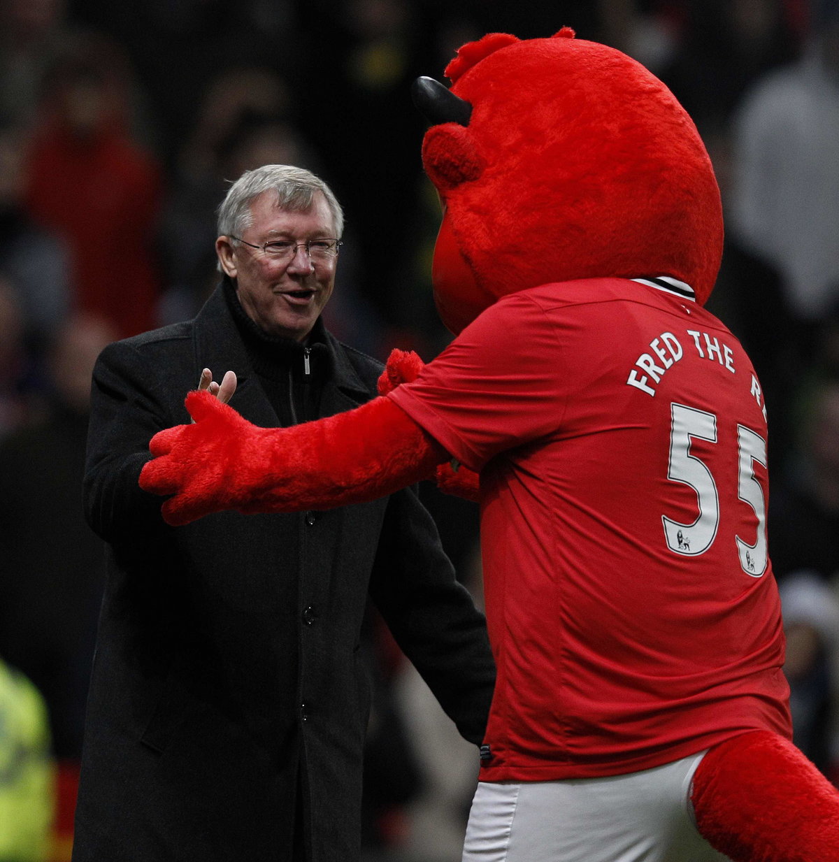 Manchester United's manager Ferguson is greeted by club mascot