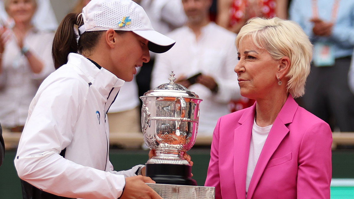 Iga Świątek (z lewej) odbierająca trofeum za wygranie Rolanda Garrosa w 2023 r.